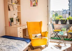 a bedroom with a bed and a yellow chair at Lovely Day in Gdynia