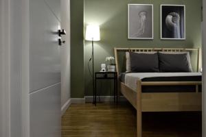 ein Schlafzimmer mit grünen Wänden und einem Bett mit einer Lampe in der Unterkunft GREEN HOUSE in Kardítsa