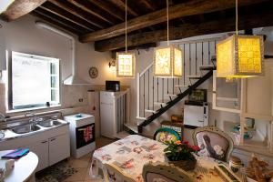 a kitchen with a table and a sink and a staircase at Castè Style Fam Holidays near Cinque Terre in Riccò del Golfo di Spezia