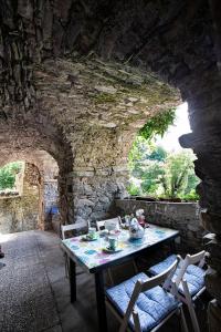リッコ・デル・ゴルフォ・ディ・スペーツィアにあるCastè Style Fam Holidays near Cinque Terreの石壁の部屋のテーブル
