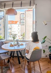 a woman sitting at a table looking out the window at Lovely Day in Gdynia