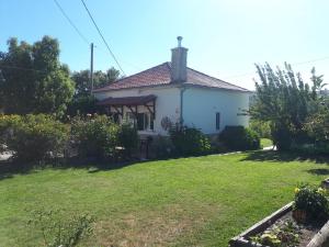 a small white house with a grass yard at Quinta do Serrado de Belmonte in Belmonte