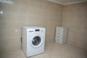 een wasruimte met een wasmachine en een kast bij DUPLEX in Tbilisi City