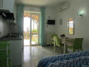a room with a kitchen and a table with chairs at Aparthotel Villa Marinù in Ischia