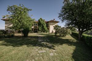 a house with a yard with trees in front of it at Agriturismo Bricco San Giovanni in Isola d'Asti