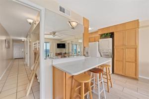 a kitchen with a counter and stools in a room at The Summit 1011 in Panama City Beach