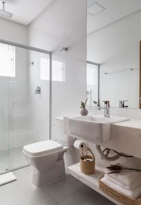 uma casa de banho branca com um lavatório e um WC em NOAH HOTEL em Capitólio