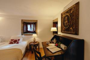 a room with a bed and a desk and a bed and a table with at Casa Agricola da Levada Eco Village in Vila Real