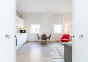 a kitchen and living room with a table and chairs at White Piccadilly Luxury Flat in London