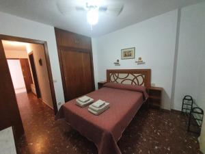 a bedroom with a bed with two towels on it at Apartamento Acogedor en Los Patios De San Basilio in Córdoba
