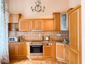 a kitchen with wooden cabinets and a chandelier at Apartmá Marie 1880 in Karlovy Vary