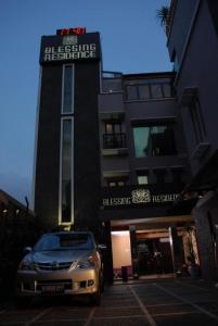 un coche aparcado en un aparcamiento frente a un edificio en BLESSING RESIDENCE HOTEL, en Yakarta