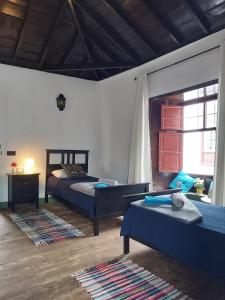 a bedroom with two beds and a window at Casa la plaza in Agulo