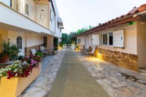 a courtyard of a house with chairs and flowers at Apartments Tina FREE transfer from-to the airport in Spata