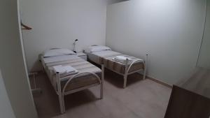 two twin beds in a small room with at ArmacHouse - Appartamenti sul mare in Reggio Calabria