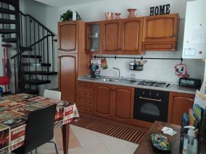 a kitchen with wooden cabinets and a sink and a table at La Casa al Colle in Treglio