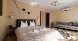 una camera da letto con un grande letto con asciugamani di Apartment Alios Lux a Braşov