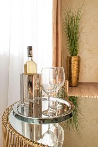 un vassoio con bicchieri da vino e una bottiglia di vino di Apartment Alios Lux a Braşov