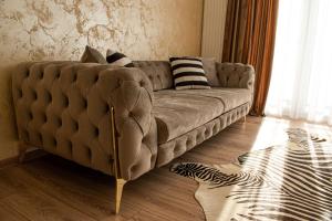 un divano marrone in soggiorno con di Apartment Alios Lux a Braşov
