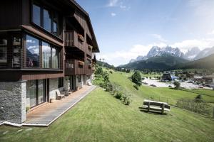 a building with a bench on the grass next to it at Gamz Villa in Sesto