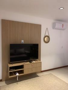 uma sala de estar com uma televisão de ecrã plano na parede em Maraú Beach House Flat 107 pé na areia - Cond Dreamland Apart Taipú de Fora Barra Grande-BA em Barra Grande