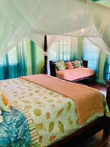 ein Schlafzimmer mit einem Bett und einem Sofa in der Unterkunft Dolphin Bay Hideaway in Bocas del Toro