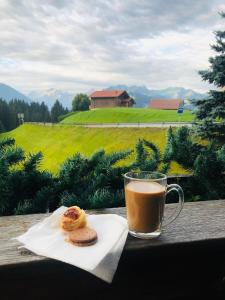 uma chávena de café e dois donuts e um copo de café em Chalet Soldanella 10 guests Gstaad em Gstaad