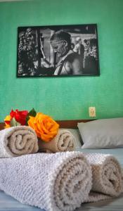 Una cama con toallas y una foto de un hombre en Pousada Recanto da Chapada en Mucugê