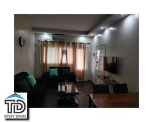 a living room with a couch and a tv at TD Guest House 4 Plus in Chimoio