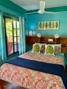 a bedroom with a bed with a blue wall at Dolphin Bay Hideaway in Bocas del Toro