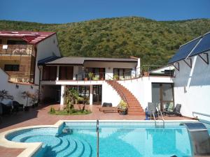 a villa with a swimming pool in front of a house at Pensiunea La Dolce Vita in Băile Herculane