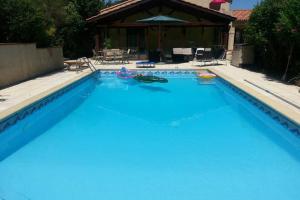 une grande piscine d'eau bleue en face d'une maison dans l'établissement Maison avec climatisation 230 M2 10 km centre Toulouse, à Montrabé