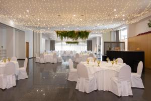 a banquet hall with white tables and white chairs at Exe Vía Argentum in Silleda