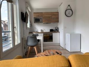 cocina con sofá y mesa en una habitación en Beautiful studio located south of Paris, en Bourg-la-Reine