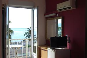Cette chambre dispose d'un balcon offrant une vue sur l'océan. dans l'établissement Hôtel Azur, à Nice
