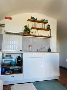 - une cuisine avec des placards blancs et un évier dans l'établissement Beach House Loft, à Cortegaça