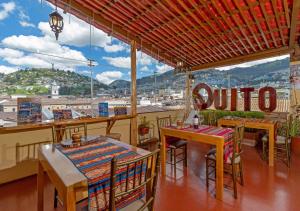 a restaurant with tables and chairs and a view of a city at Friends Hotel & Rooftop in Quito