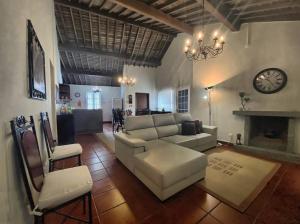 ein Wohnzimmer mit einer Couch und Stühlen und einer Uhr in der Unterkunft Casa na Ribeira in Ribeira Grande