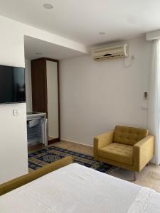 a bedroom with a bed and a chair and a television at Apartments Gjenashaj in Ulcinj