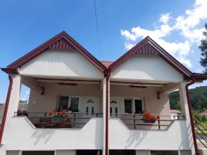 a house with a balcony with flowers on it at Apartmani Pejovic in Mojkovac