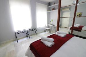 um quarto com uma cama com duas almofadas em Apartamento Cristo de Burgos - Kainga Homes em Sevilha