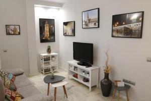 uma sala de estar com um sofá e uma televisão em Apartamento Cristo de Burgos - Kainga Homes em Sevilha