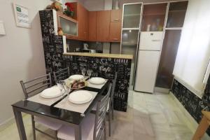 d'une cuisine avec une table et un mur noir avec un tableau noir. dans l'établissement Apartamento Cristo de Burgos - Kainga Homes, à Séville 10 autres photos