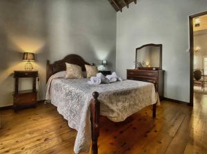ein Schlafzimmer mit einem Bett mit einer Kommode und einem Spiegel in der Unterkunft Casa na Ribeira in Ribeira Grande