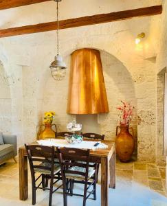 a dining room with a wooden table and chairs at All'ombra dei lecci in Alberobello