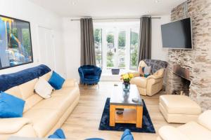 a living room with a couch and a fireplace at Modern House in Looe, Near Beach and Bars with Great Views and free access to a nearby Indoor Swimming Pool in Looe