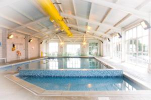 an indoor swimming pool with a large ceiling at Modern House in Looe, Near Beach and Bars with Great Views and free access to a nearby Indoor Swimming Pool in Looe