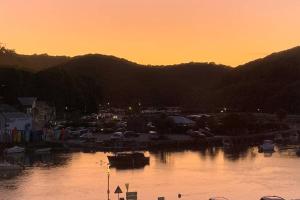 a sunset over a marina with cars and a city at Modern House in Looe, Near Beach and Bars with Great Views and free access to a nearby Indoor Swimming Pool in Looe