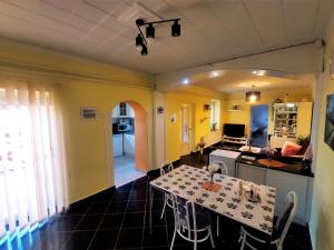 a kitchen and dining room with a table and chairs at Szandra Vendégház in Öskü