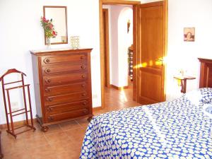 ein Schlafzimmer mit einer Kommode und einem Bett mit einer blauen und weißen Decke in der Unterkunft Appartamenti Il Girasole in Greve in Chianti